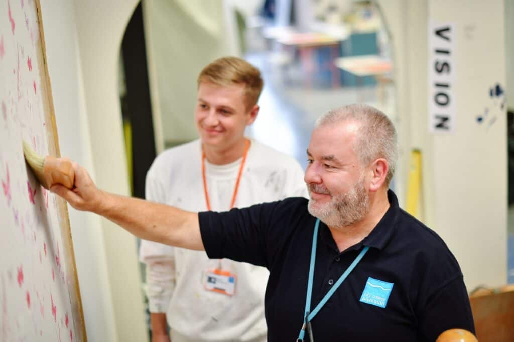 Painting and decorating lecturer giving instructions to a student