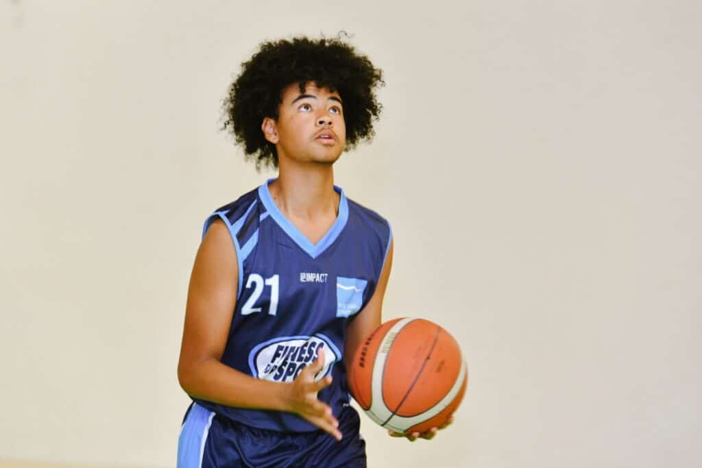 Young male student plays basketball