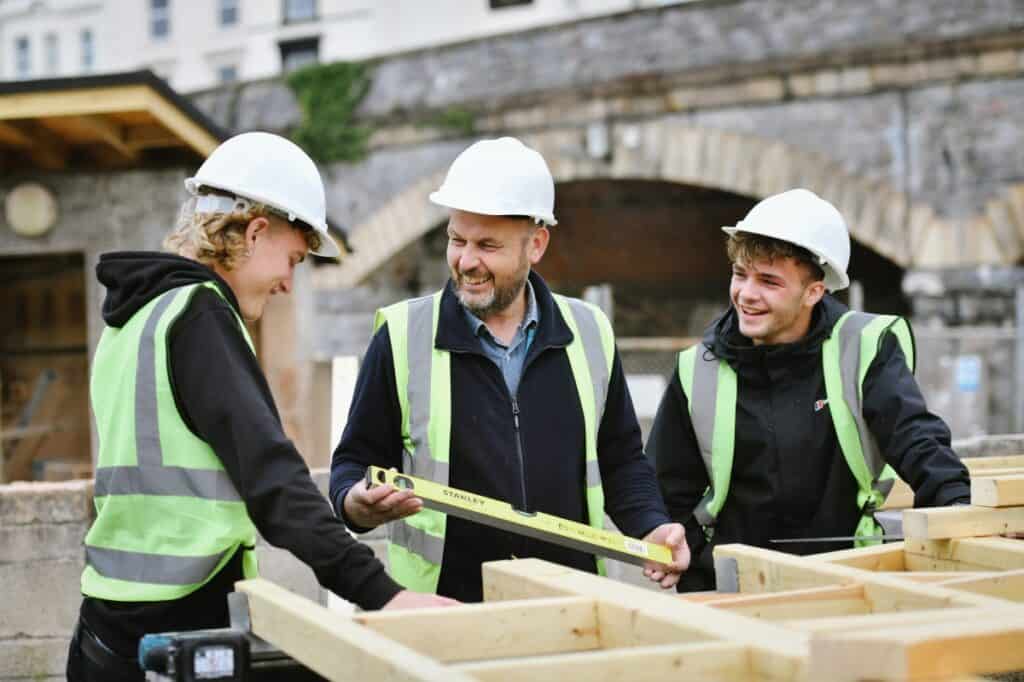 Carpentry lecturer working onsite with students