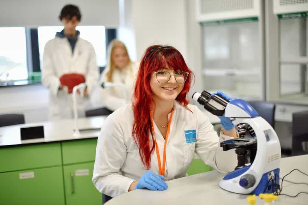 A young female science student using a microscope