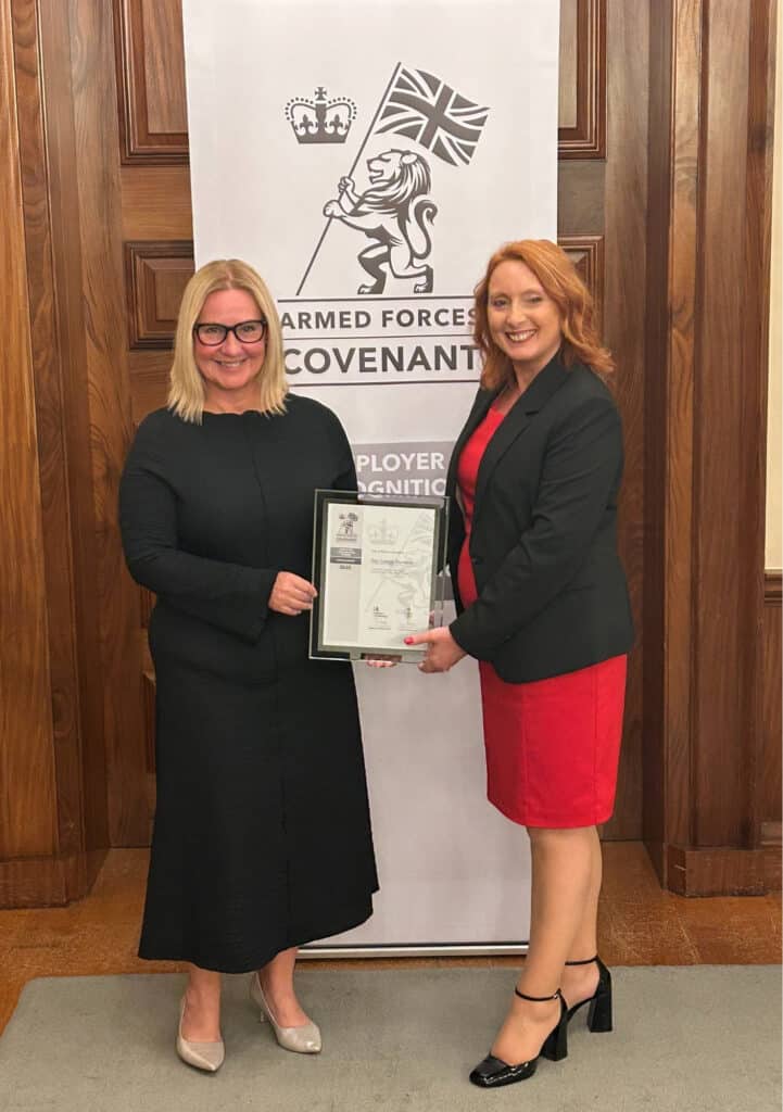 Jackie Grubb and Pauline Hands hold the Silver ERS award in front of a banner at Exeter County Hall
