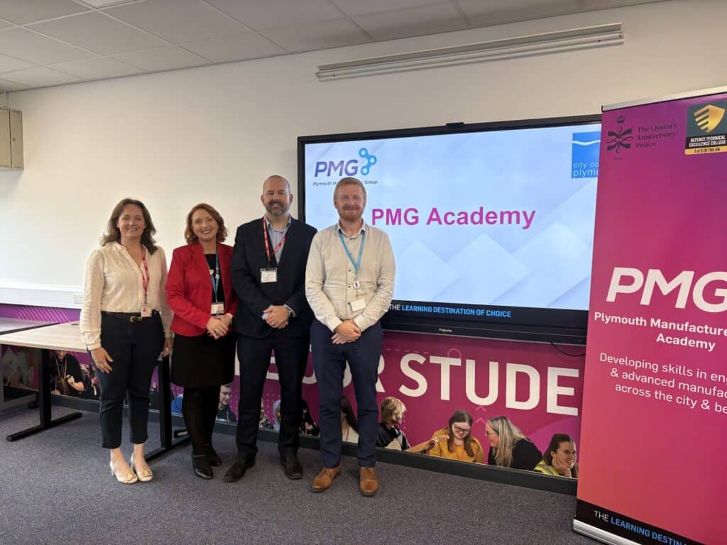 Four members of staff pose by the PMG academy sign at City College Plymouth